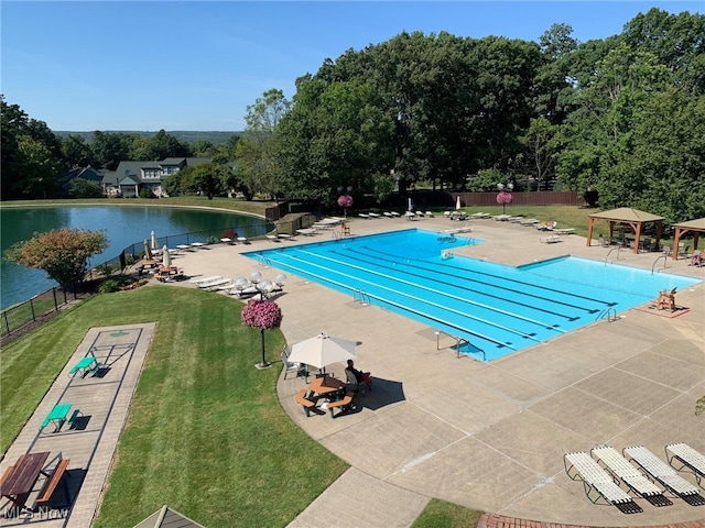 community pool featuring a water view, fence, a gazebo, a lawn, and a patio area