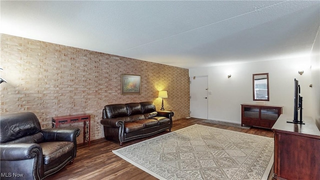 living area with a textured ceiling and wood finished floors