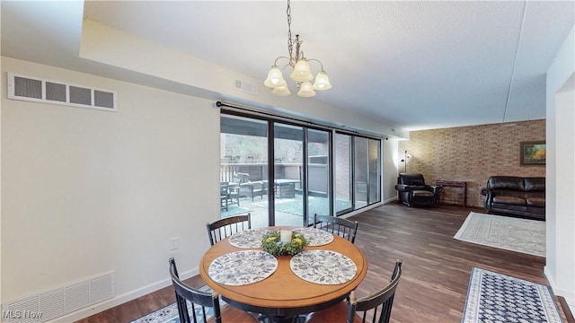 dining area with baseboards, visible vents, a chandelier, and wood finished floors