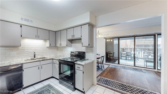 kitchen with tasteful backsplash, visible vents, a sink, a textured ceiling, and black appliances