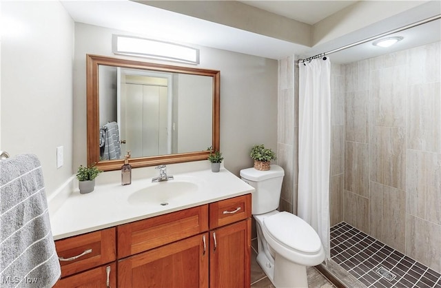 full bath featuring tiled shower, vanity, and toilet