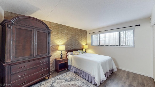 bedroom with baseboards and wood finished floors