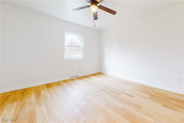 unfurnished room featuring light wood-type flooring, baseboards, and visible vents