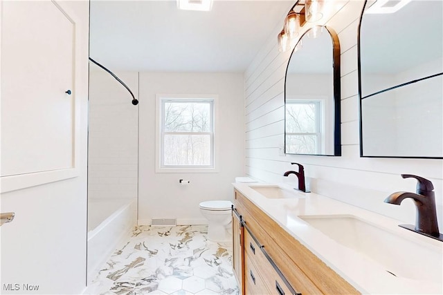 full bathroom featuring marble finish floor, a sink, toilet, and double vanity