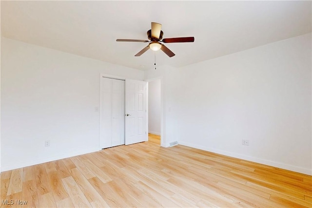 spare room featuring light wood-style flooring, baseboards, and a ceiling fan