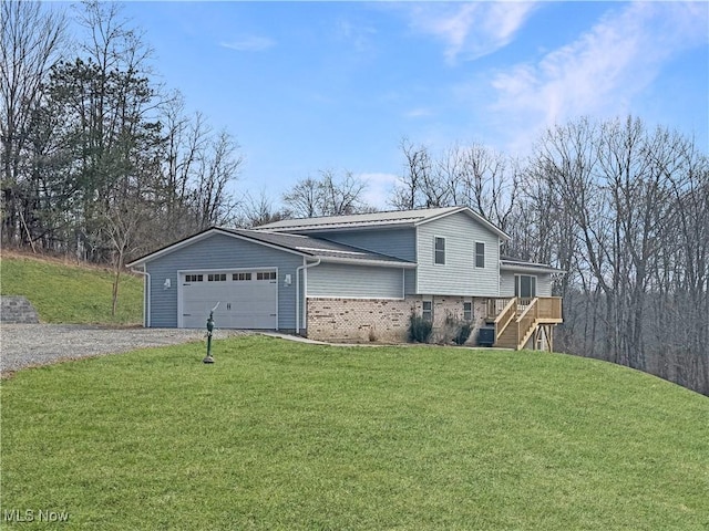 view of side of property with brick siding, a lawn, stairway, a garage, and driveway