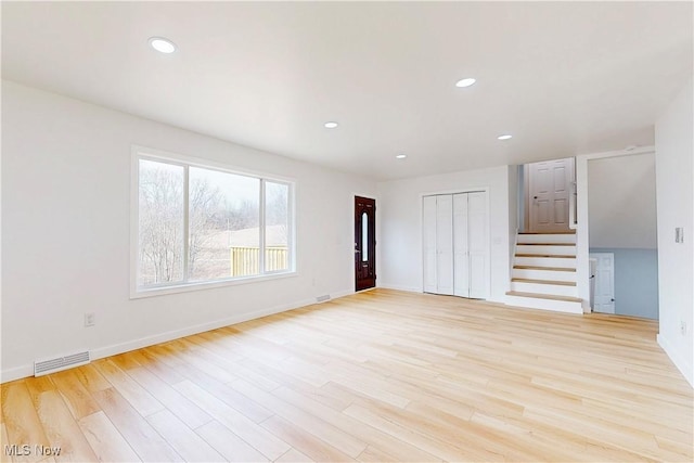 unfurnished room with stairs, light wood finished floors, visible vents, and recessed lighting