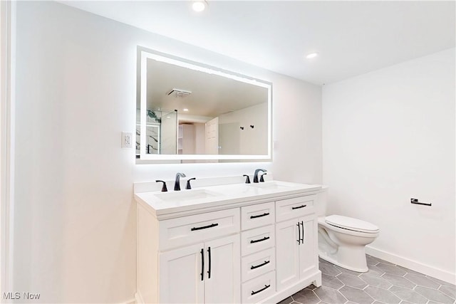 full bath with tile patterned floors, a sink, toilet, and double vanity