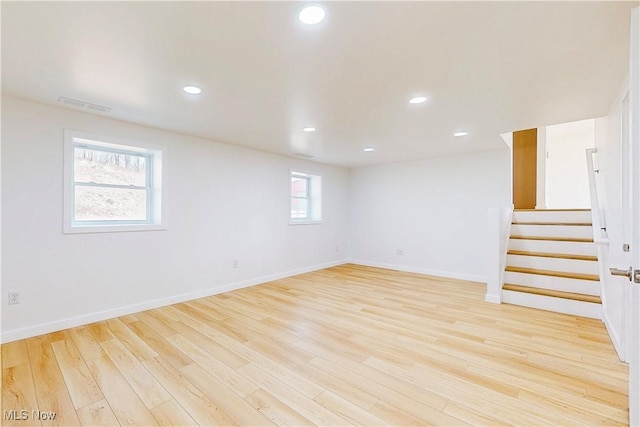 basement with light wood-type flooring, stairs, baseboards, and recessed lighting