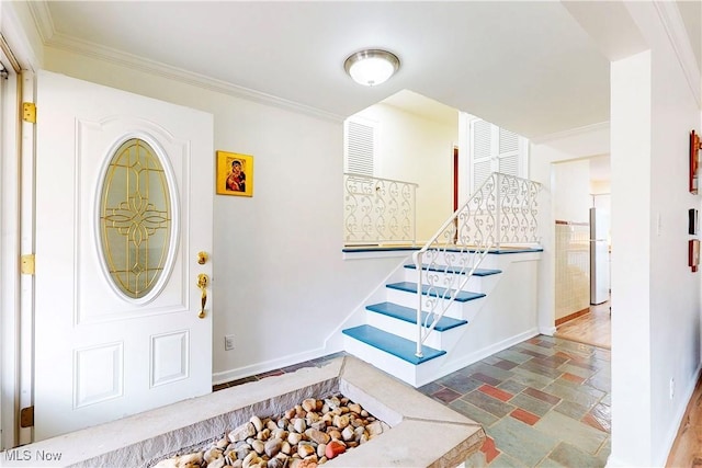 entryway with baseboards, stone finish flooring, stairway, and crown molding