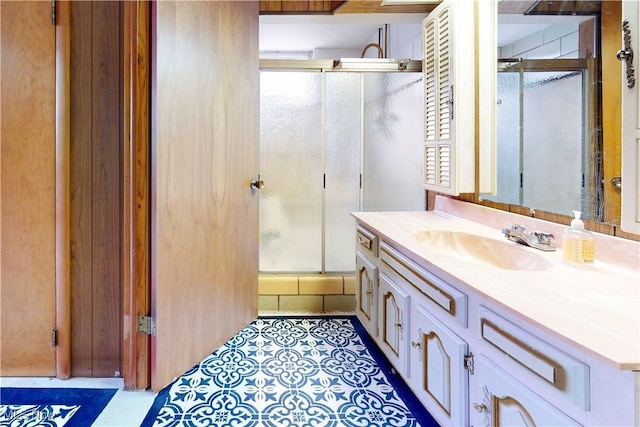 bathroom featuring a shower with shower door and vanity