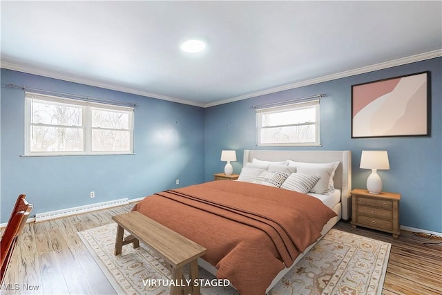 bedroom with crown molding, baseboards, baseboard heating, and wood finished floors