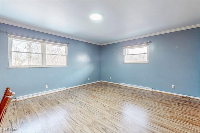 unfurnished room with a baseboard heating unit, crown molding, baseboards, and wood finished floors