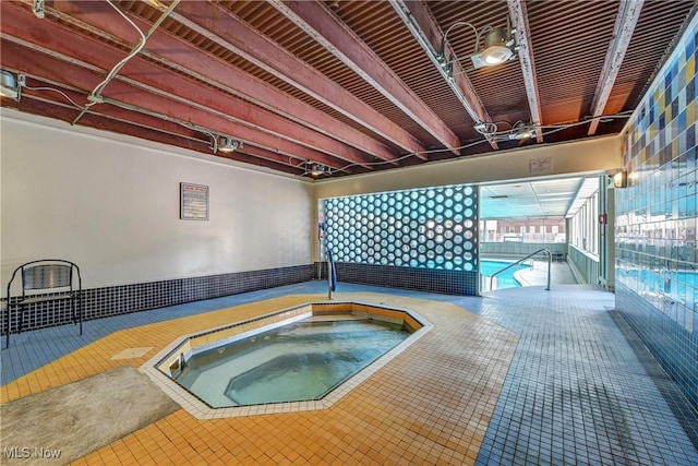 view of swimming pool with an indoor hot tub