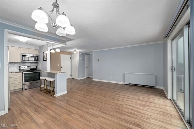 kitchen with crown molding, appliances with stainless steel finishes, backsplash, and light wood-style floors