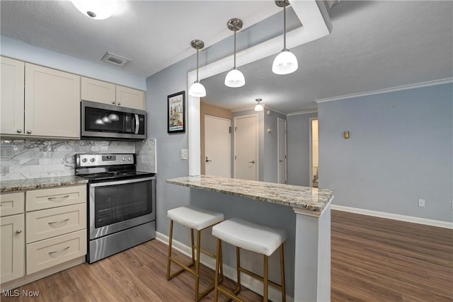 kitchen with stainless steel appliances, a peninsula, visible vents, decorative backsplash, and dark wood-style floors