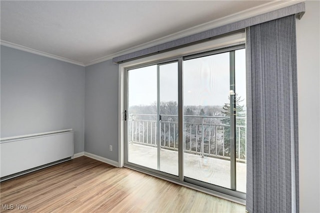 spare room with ornamental molding, baseboards, and wood finished floors