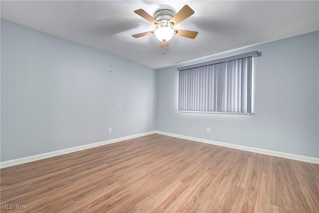 unfurnished room featuring ceiling fan, wood finished floors, and baseboards