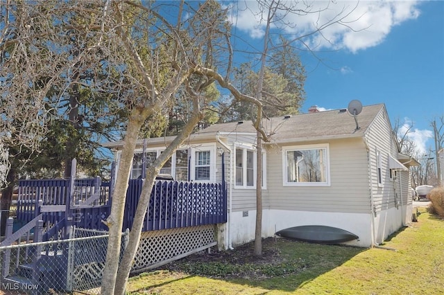 view of home's exterior featuring a deck and a yard