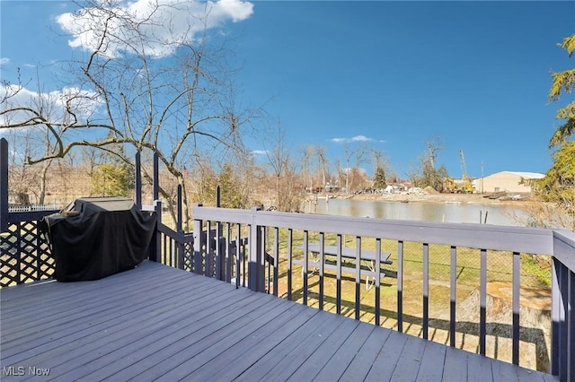 wooden terrace featuring a water view and a grill