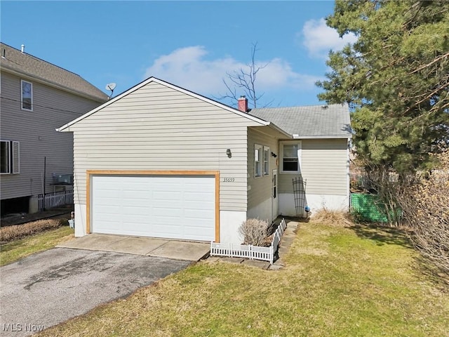 view of front facade featuring a garage, driveway, a chimney, and a front yard