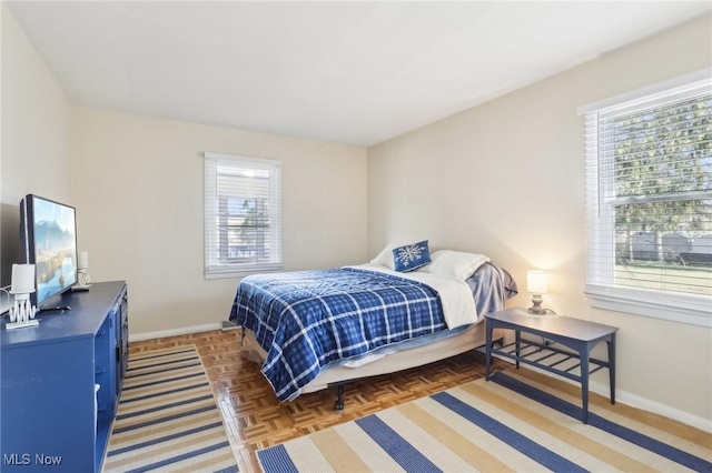 bedroom featuring multiple windows and baseboards