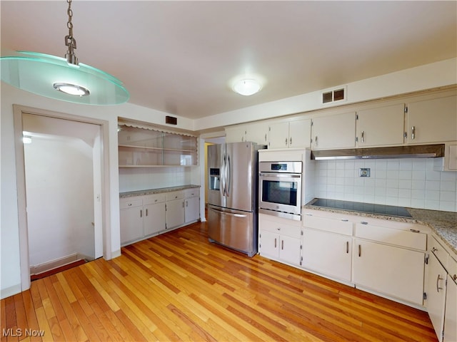 kitchen with stainless steel appliances, light wood finished floors, visible vents, and tasteful backsplash