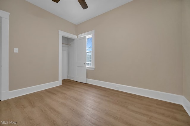 unfurnished bedroom with a ceiling fan, a closet, baseboards, and light wood finished floors