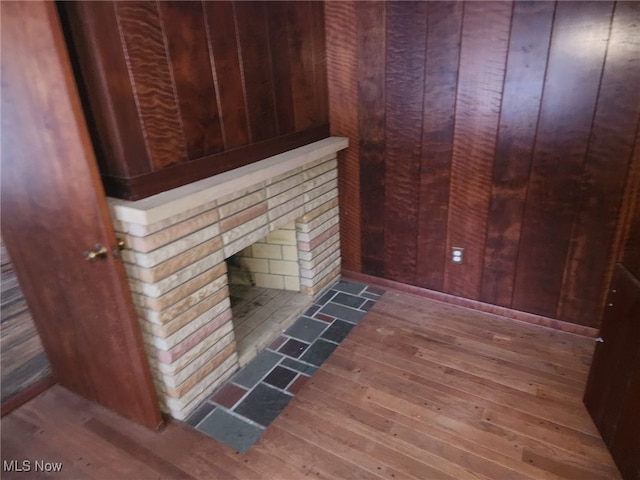 details featuring a sauna, a fireplace, wood finished floors, and wooden walls