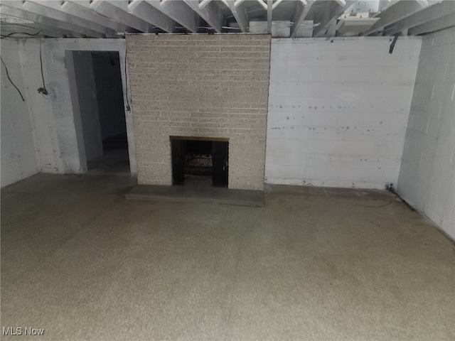 unfinished basement featuring a brick fireplace