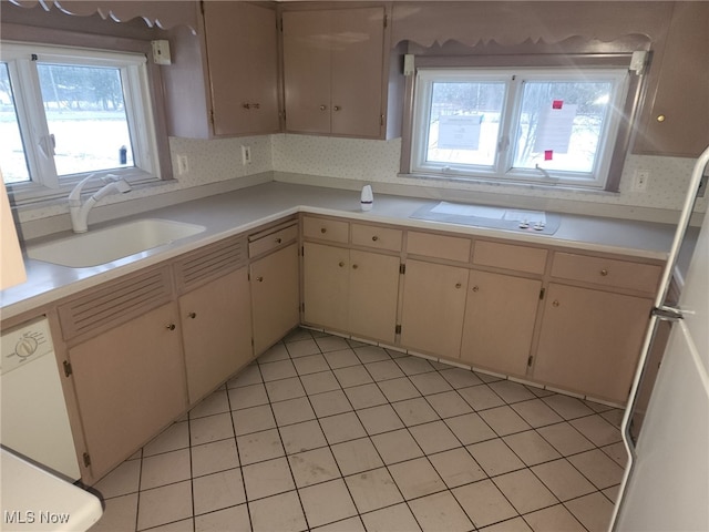 kitchen with white appliances, light countertops, a sink, and light tile patterned floors