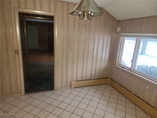 empty room featuring a baseboard heating unit, lofted ceiling, light tile patterned flooring, and wooden walls