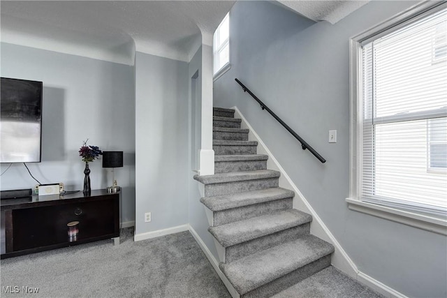 stairway featuring carpet and baseboards