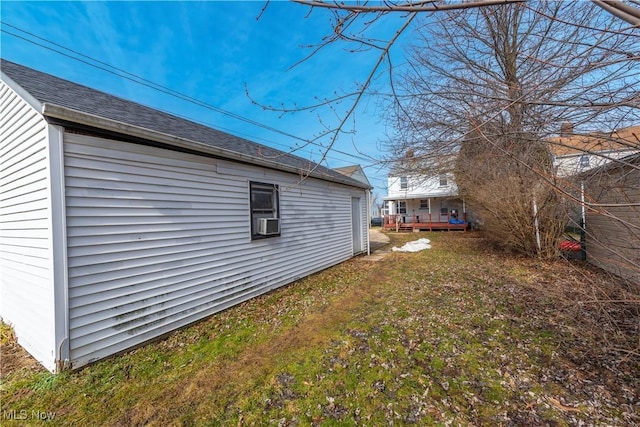 view of side of property with a shingled roof and cooling unit