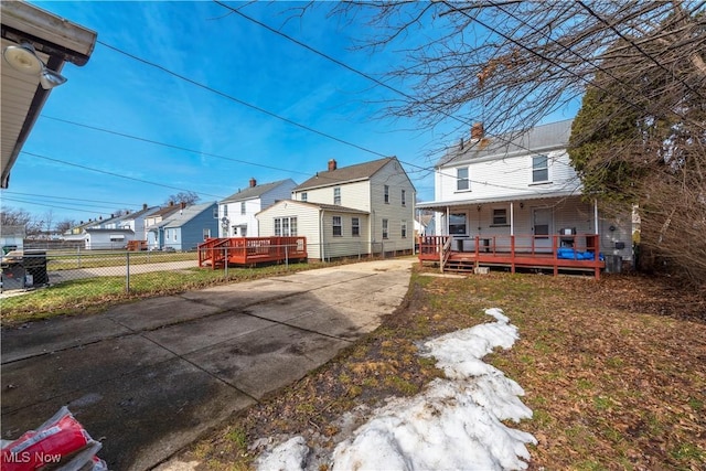 rear view of house with a porch, fence, and a residential view