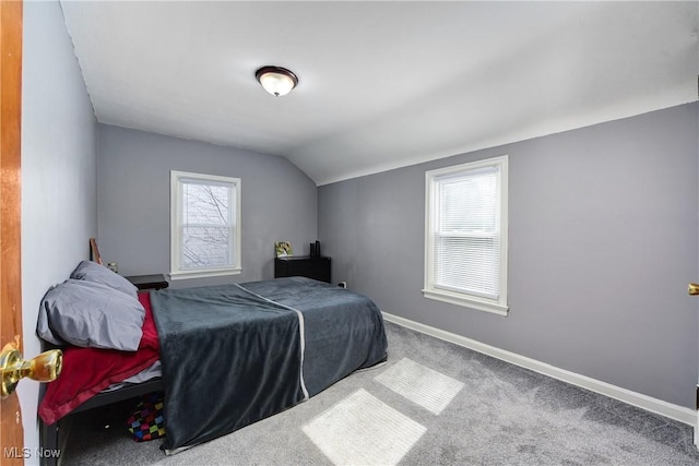 bedroom with carpet flooring, vaulted ceiling, and baseboards