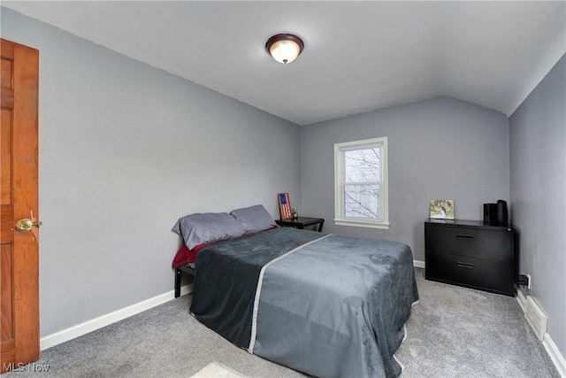 bedroom with lofted ceiling, baseboards, and light colored carpet