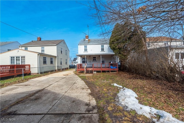 rear view of property featuring a porch and concrete driveway