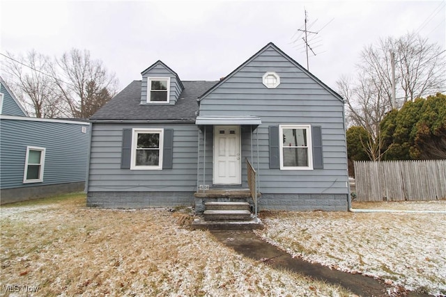 view of front of home with a shingled roof and fence