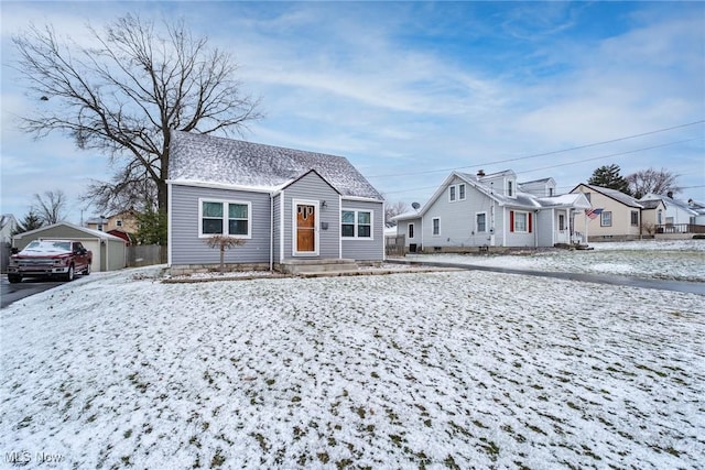 bungalow featuring a garage, roof with shingles, and an outdoor structure