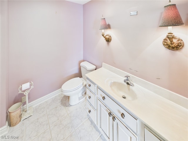 bathroom with baseboards, vanity, and toilet