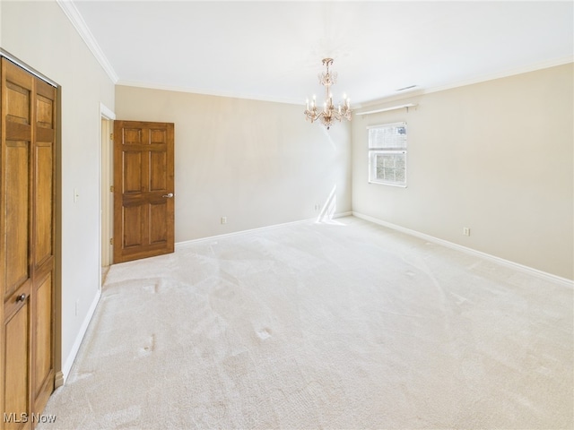 spare room featuring a notable chandelier, ornamental molding, light carpet, and baseboards