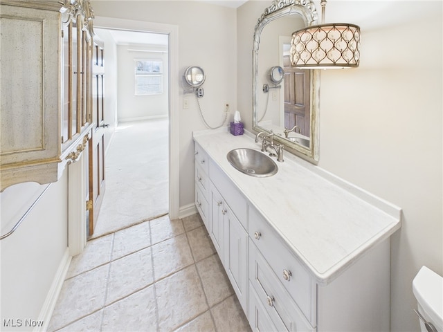 bathroom featuring toilet, vanity, and baseboards