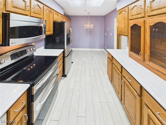 kitchen featuring stainless steel appliances, light wood-type flooring, and light countertops