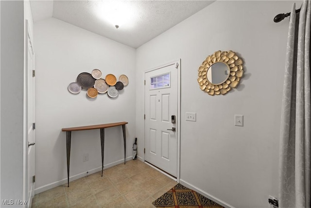 entrance foyer with lofted ceiling, baseboards, and a textured ceiling