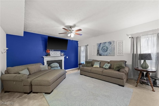 living area with carpet floors, a fireplace, and a ceiling fan