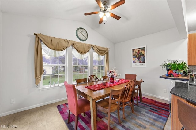 dining room featuring ceiling fan, baseboards, and vaulted ceiling