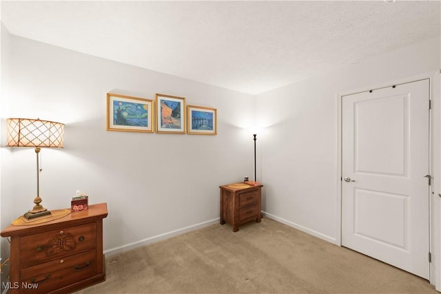 bedroom with baseboards and light colored carpet