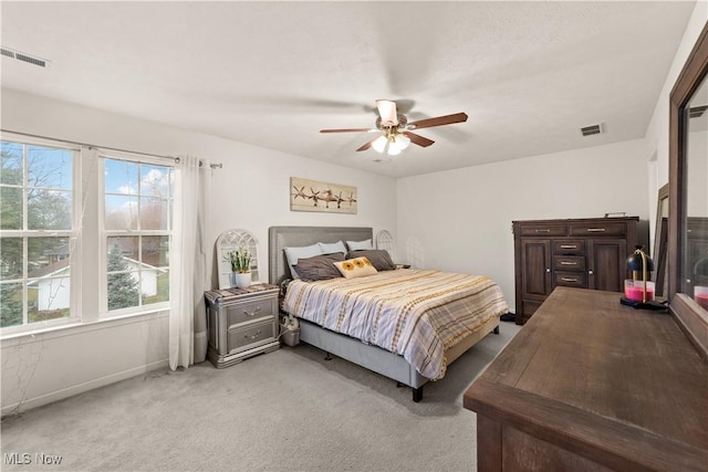 bedroom with a ceiling fan, light colored carpet, and visible vents