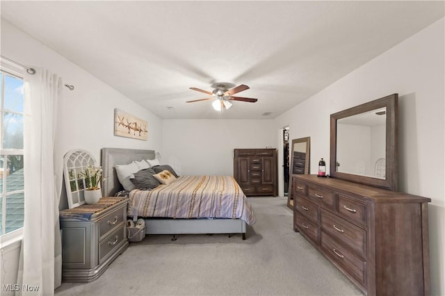 bedroom with light carpet and a ceiling fan